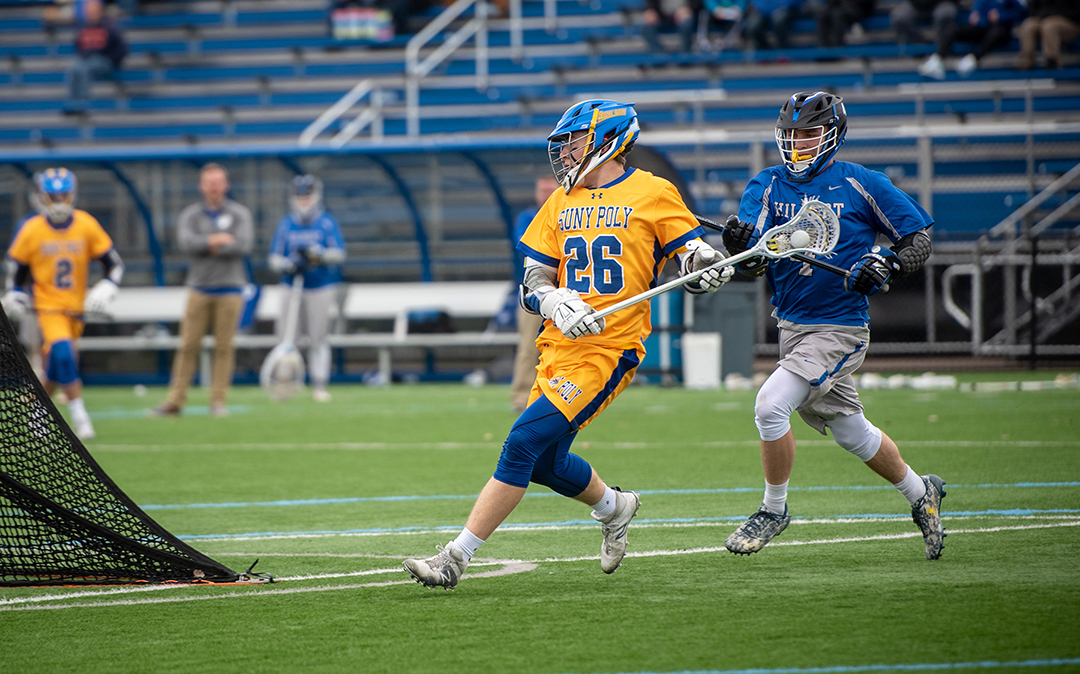 SUNY Poly men's lacrosse player running on the field during a game