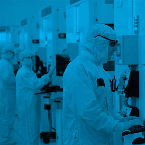 workers standing at computers in a clean room