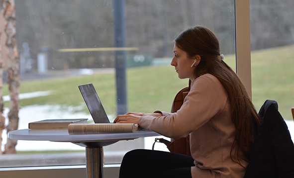 Femail student on a computer in front of a window