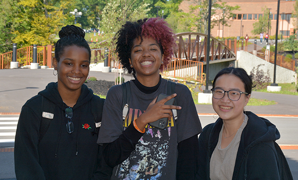 three students smiling on campus