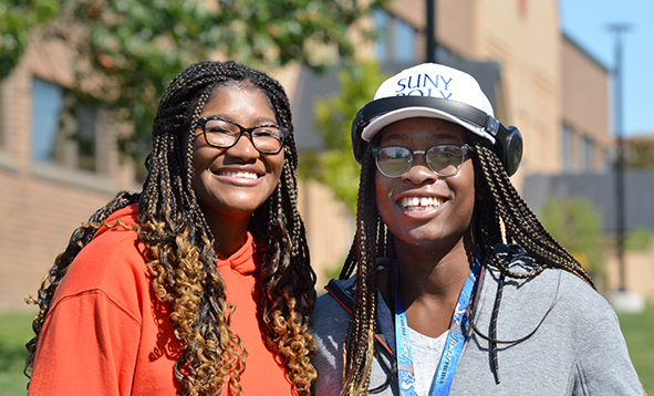 two students smiling for a photo on a sunny day