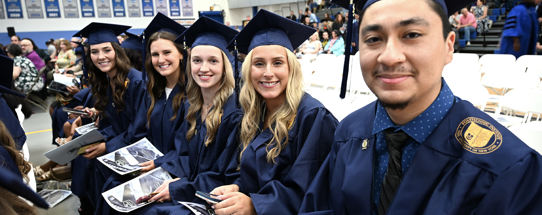 five college students posing for a picture at graduation