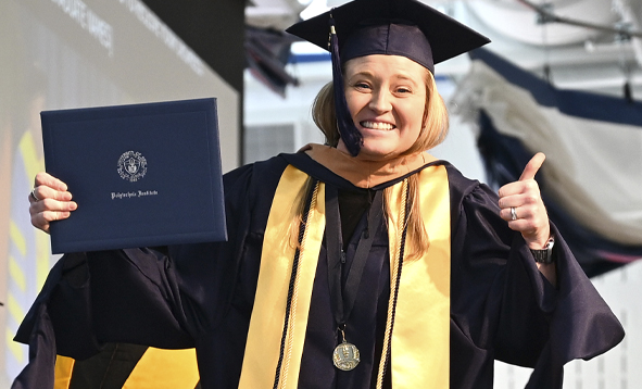 A college graduate giving a thumbs up